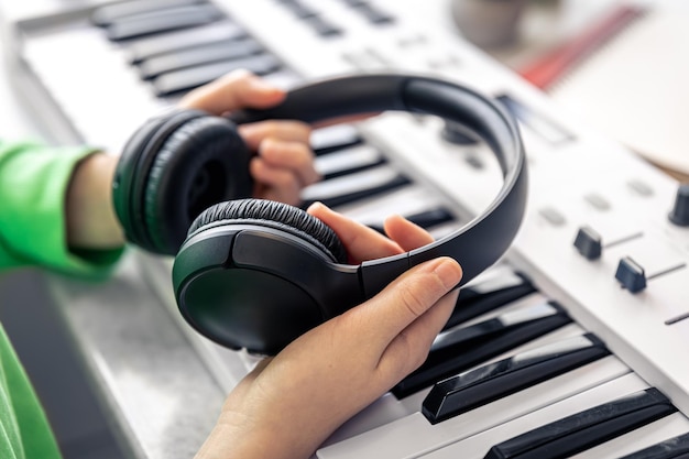 Auriculares negros de primer plano en manos de un concepto de música infantil