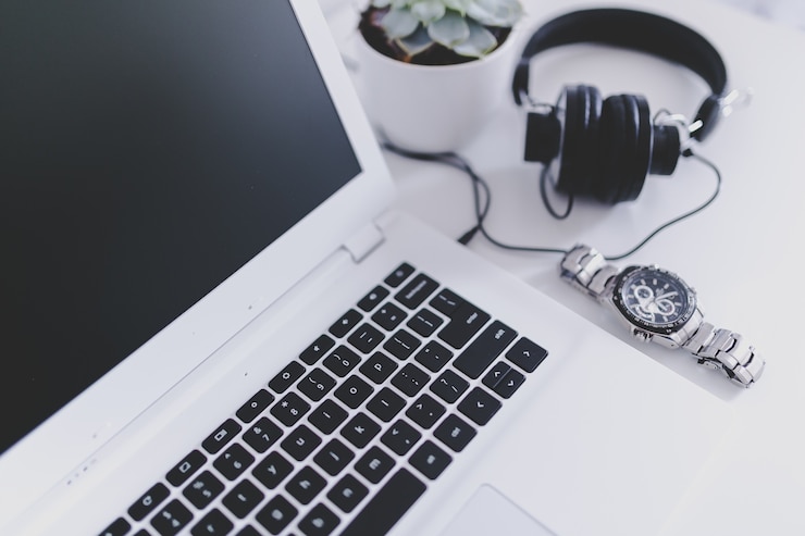 Foto gratuito auriculares, reloj y un portátil