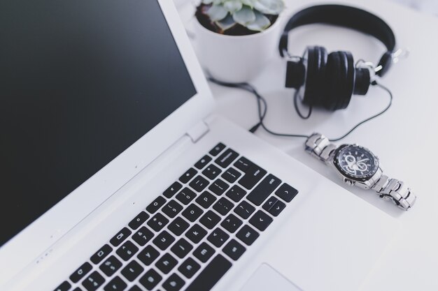 Auriculares, reloj y un portátil