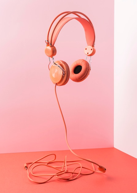 Auriculares rosa con cable volando