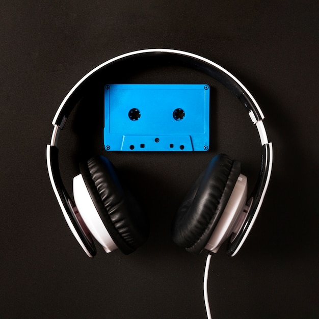 Auriculares sobre la cinta de cassette azul sobre fondo negro