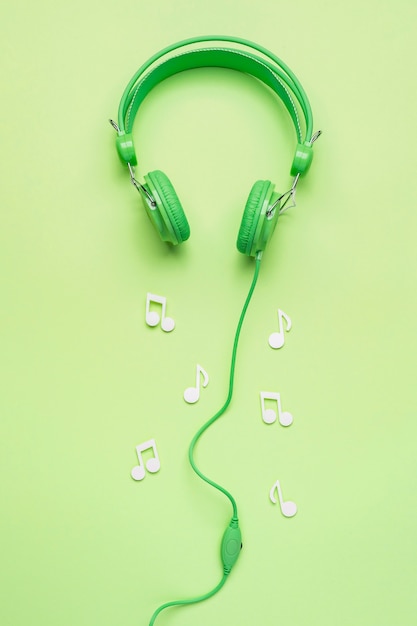 Auriculares verdes con notas musicales blancas