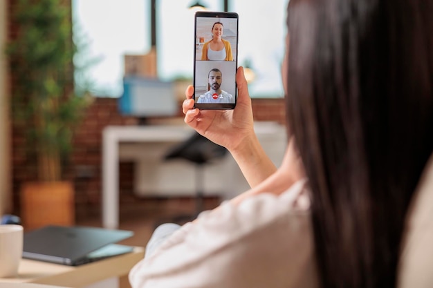 Foto gratuita auténtica mujer asiática ocupada en videollamada reunión comunicación en línea trabajando desde casa hablando aplicación móvil saludando hola tecnología de internet feliz llamada negocio independiente hablar