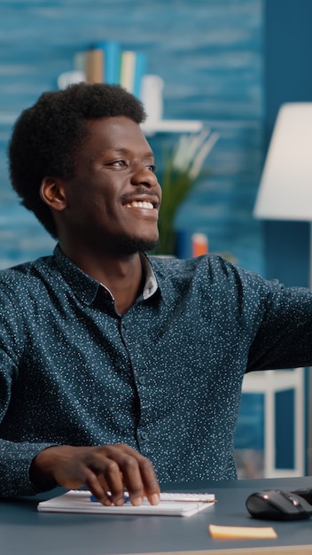 Auténtico joven feliz sonriendo y tomando un selfie en la sala de estar para compartirlo en las redes sociales