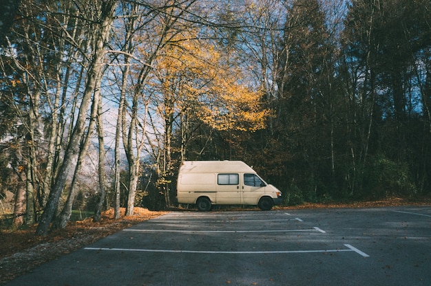 Autocaravana estacionada en el estacionamiento en el bosque. Concepto de camping y aventura.