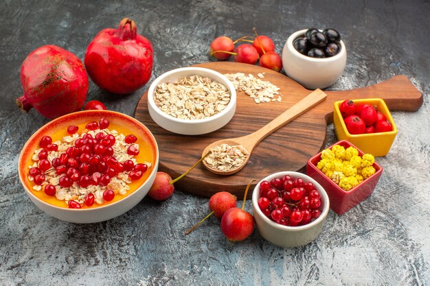 avena avena en el tablero dos granadas grosellas rojas cerezas uvas