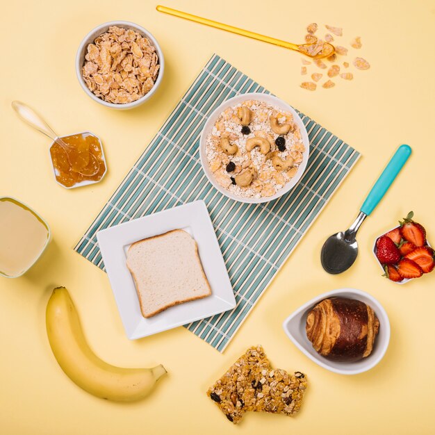 Avena en un bol con tostadas y frutas en la mesa