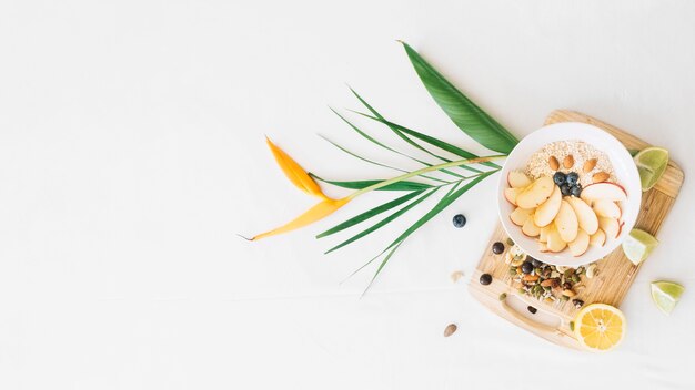 Avena y frutos secos con flor de ave del paraíso sobre fondo blanco