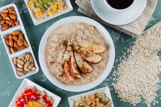 Avena en platos con frutas, mermelada, nueces, canela, café, copos de avena