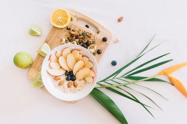 Avena saludable y frutos secos en la tabla de cortar con flor