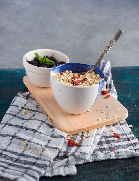 Foto gratuita avena en taza con bayas en tablero de madera