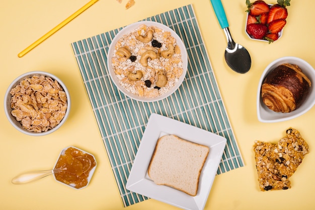 Foto gratuita avena en un tazón con pan tostado y bayas en la mesa