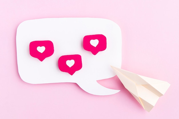 Foto gratuita avión de papel con iconos de corazón