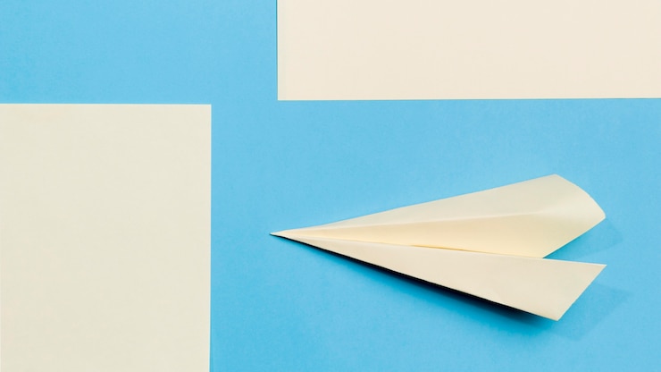 Foto gratuito avión de papel de primer plano en el escritorio