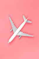 Foto gratuita avión sobre un concepto de viaje plano de fondo rosa