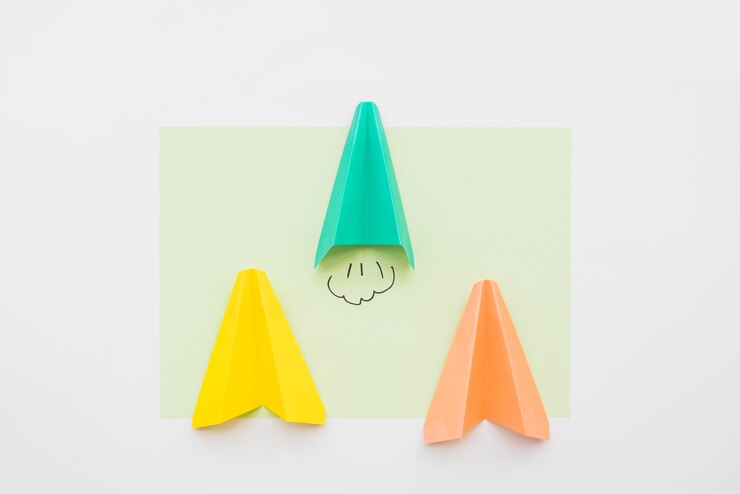 Foto gratuito aviones de juguete hechos de hojas de papel de colores.