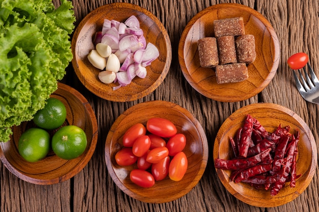 Foto gratuita azúcar de palma, cebollas rojas, pimientos secos, tomates, pepinos, judías largas y lechuga en un tazón.