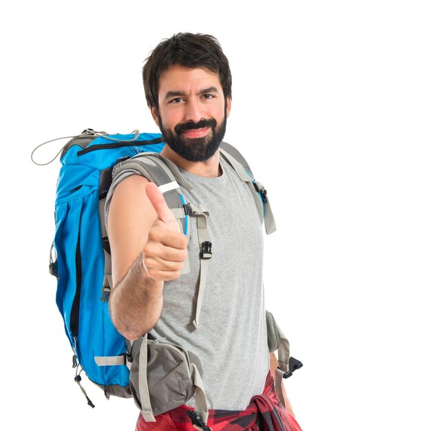 Backpacker con el pulgar hacia arriba sobre fondo blanco