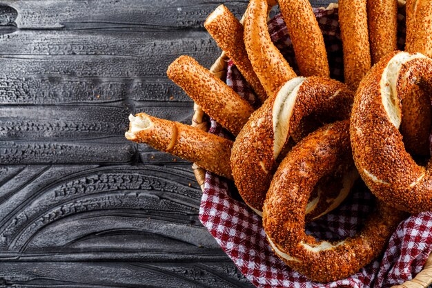 Bagel turco en una vista superior de la cesta sobre una superficie de madera oscura, espacio para texto