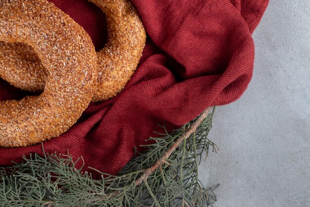 Bagels recubiertos de sésamo sentado en un arreglo decorativo sobre superficie de mármol