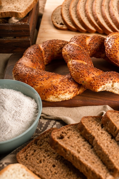 Bagels sabrosos con rebanadas de pan y tazón de harina