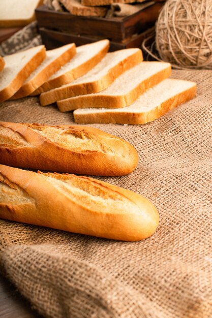 Baguette francés con rebanadas de pan sobre mantel