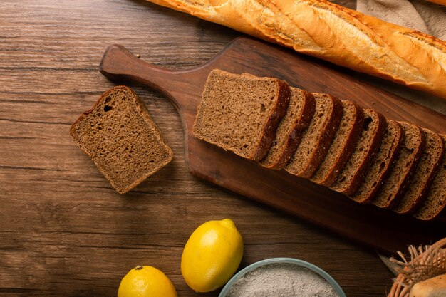 Baguette francesa con rebanadas de pan integral y limones