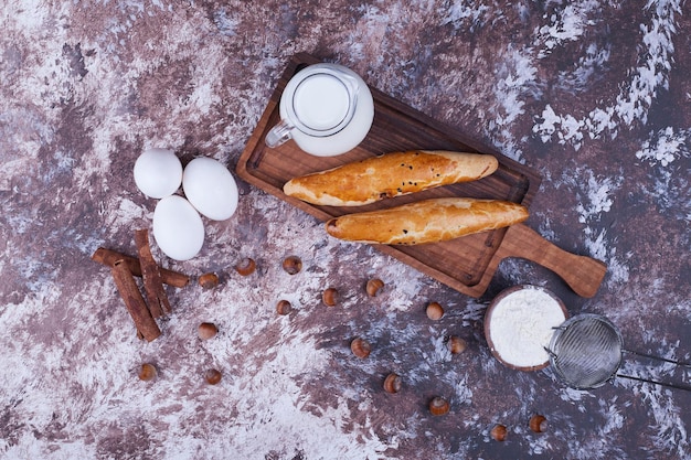 Baguettes en una bandeja de madera con ingredientes a un lado, vista superior. Foto de alta calidad