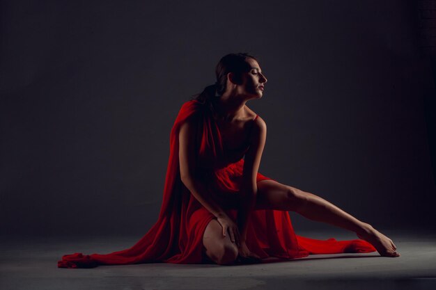 Bailarín de ballet o bailarina clásica bailando aislado sobre fondo oscuro