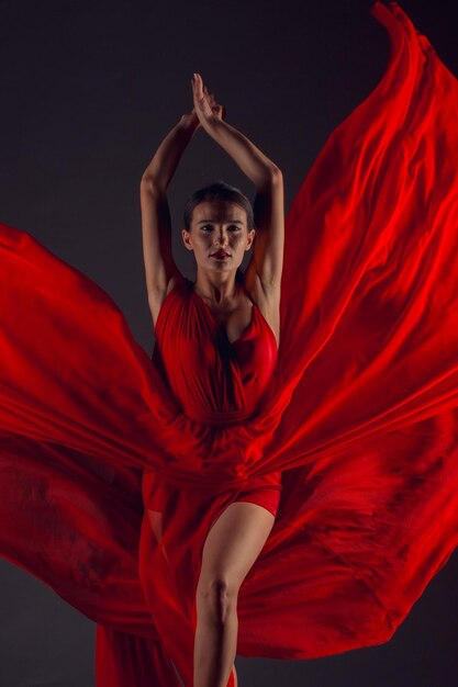 Bailarín de ballet o bailarina clásica bailando aislado sobre fondo oscuro