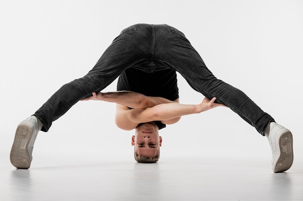 Foto gratuita bailarín en jeans y zapatillas posando mientras torcido