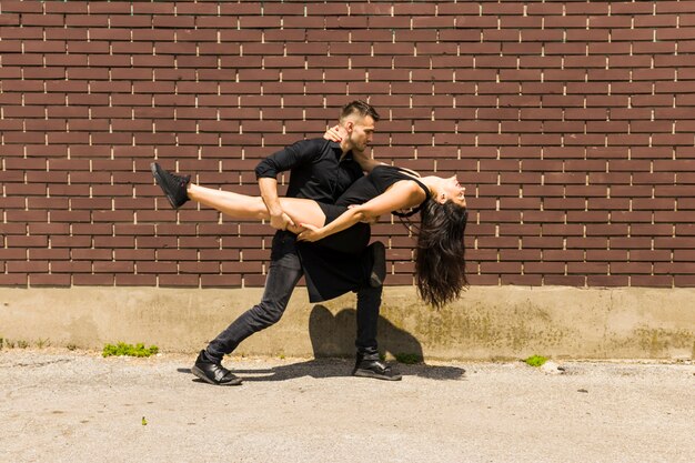 Bailarín de tango sexy bailando contra la pared