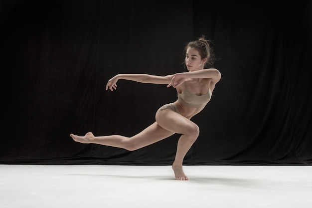 Bailarina adolescente joven en suelo blanco.