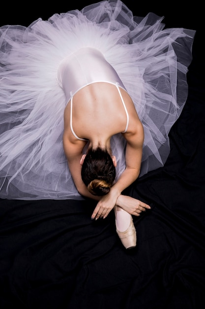 Bailarina de alto ángulo sentado en su pierna