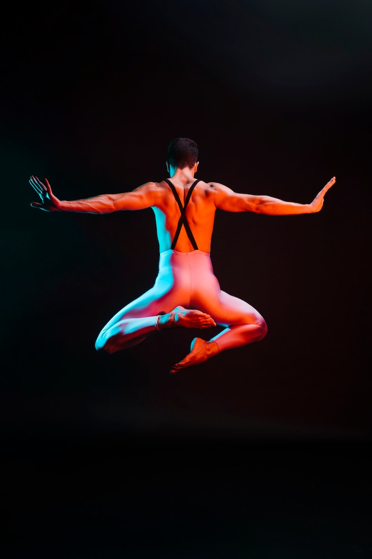 Foto gratuito bailarina de ballet irreconocible saltando con los brazos extendidos en foco
