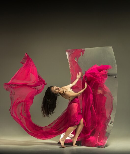 Bailarina de ballet moderno joven y elegante en marrón con espejo
