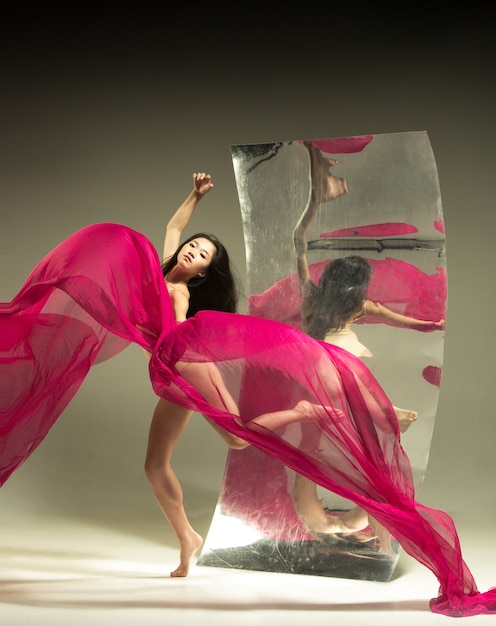 Foto gratuita bailarina de ballet moderno joven y elegante en marrón con espejo