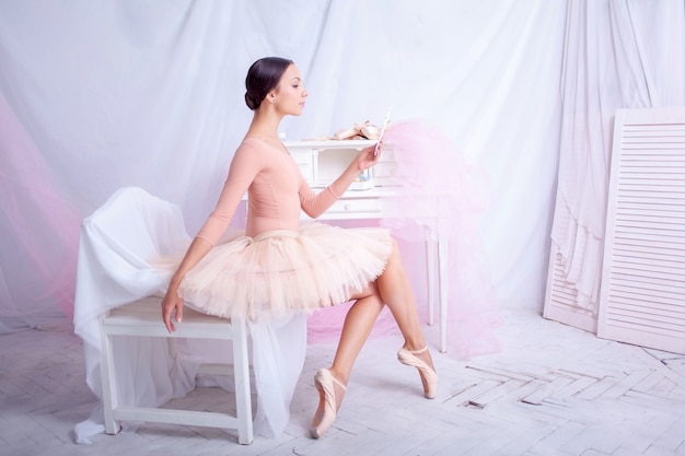 Bailarina de ballet profesional mirando en el espejo en rosa