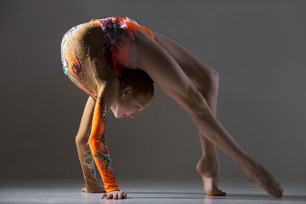 Bailarina chica haciendo ejercicio puente