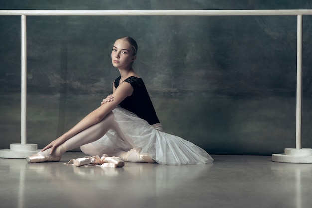 Foto gratuita la bailarina clásica posando en la barra de ballet