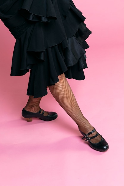 Foto gratuita bailarina de flamenco posando piernas sobre fondo rosa