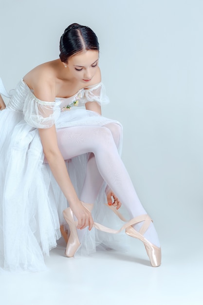 Bailarina profesional poniéndose sus zapatos de ballet