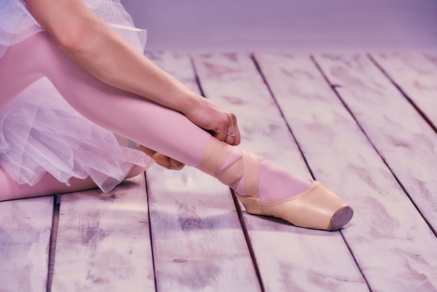 Bailarina profesional poniéndose sus zapatos de ballet