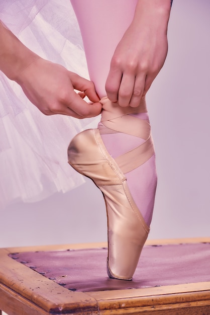 Foto gratuita bailarina profesional poniéndose sus zapatos de ballet