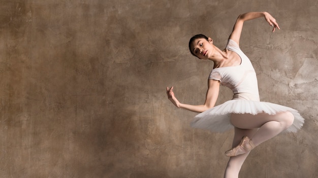 Bailarina vistiendo un tutú bailando con espacio de copia