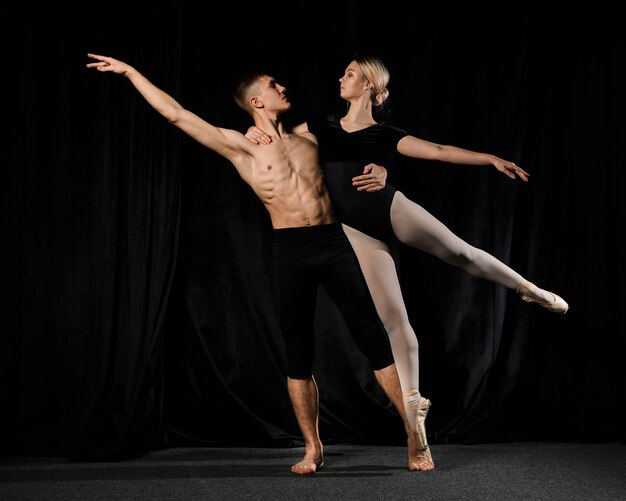 Bailarines de ballet posando con los brazos extendidos