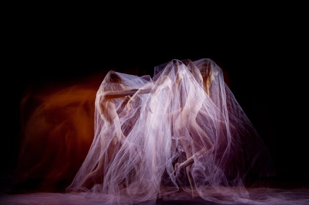 El baile sensual y emocional de la bella bailarina con velo. Técnica de fotografía con luz estroboscópica