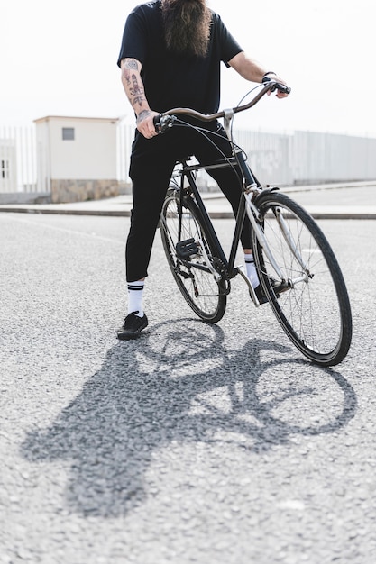 Baja sección de un hombre sentado en bicicleta