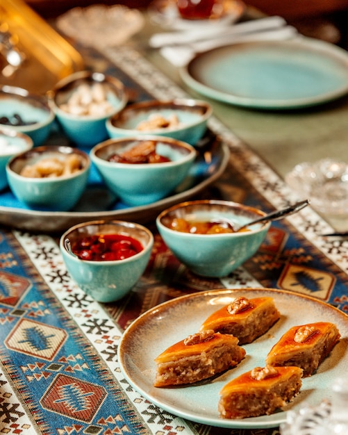 Baklava algunas mermeladas y frutas secas en la mesa