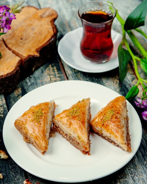 Baklava turco con nueces y una taza de té caliente